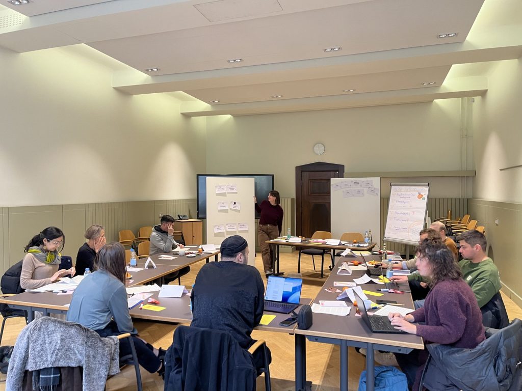 Szene der Jurysitzung 2025. 10 Personen in einem Raum im Rathaus Neukölln.